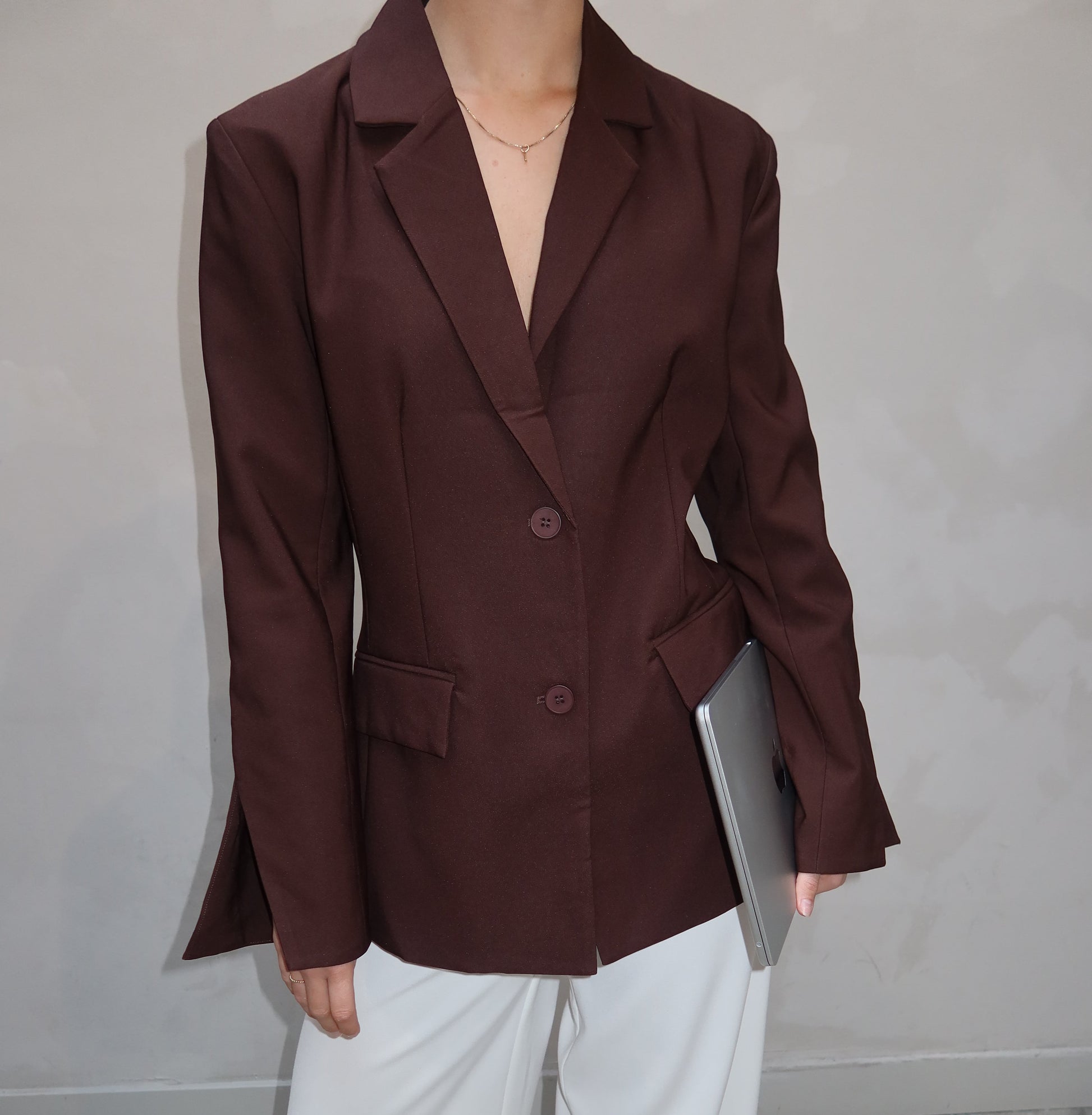 Brown coat and white pants on a gray floor